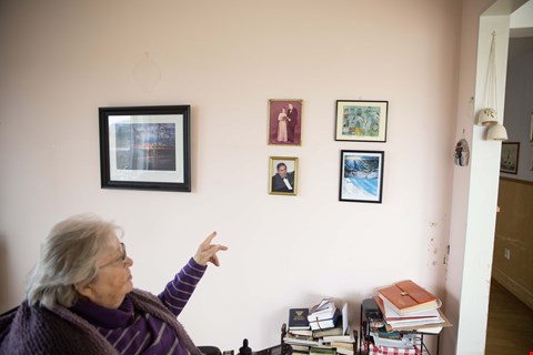 MYE HISTORIE: Liv viser frem minner fra et langt liv. På veggen i stua henger det et bilde av Glomma, bilder av hennes avdøde mann Johan og ett av hennes mange dikt.